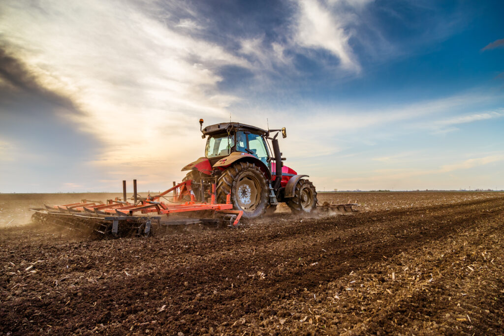 listings tractor cultivating field at spring